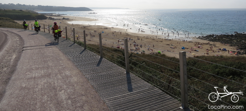 Long distance family cyclists in Brittany on Eurovelo 4, overlooking a nice beach