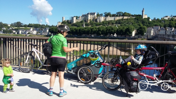 Vue sur un château sur le parcours de la Loire à Vélo avec un enfant à l'avant d'un tandem Pino